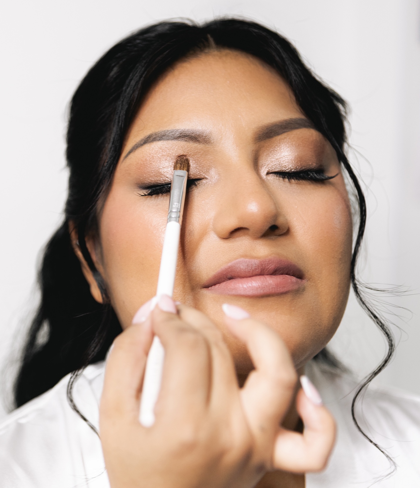 Aplicación profesional de maquillaje de novia durante la prueba