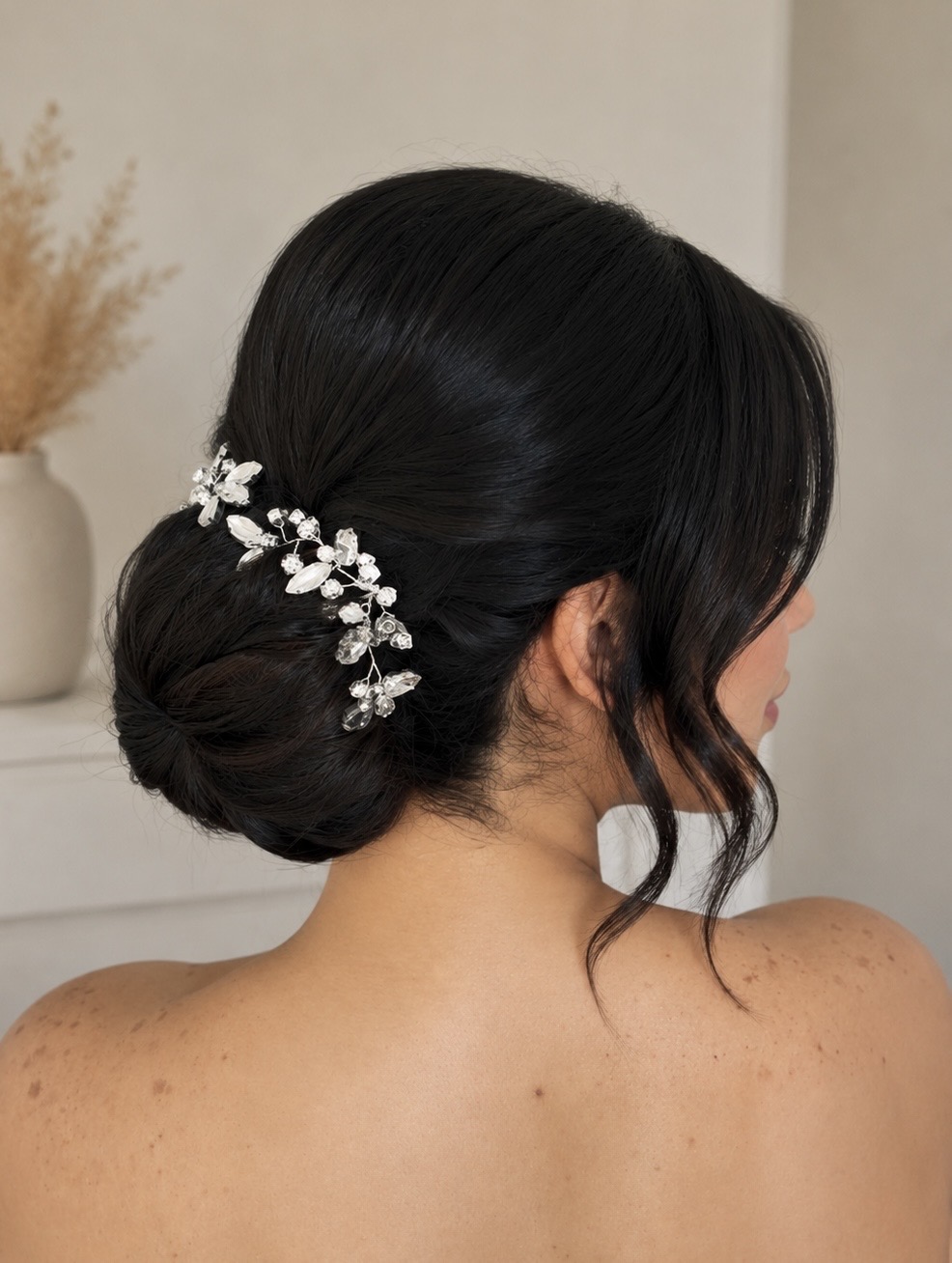 Moño bajo de novia con horquillas decorativas